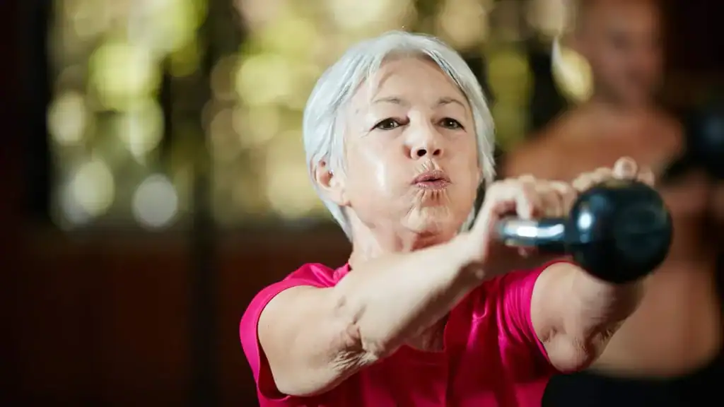Toning Arms After 60: Empowering Womens Fitness Through Effective Weight Training 1 Older woman doing weight training West Bridgford to help her strength and longevity