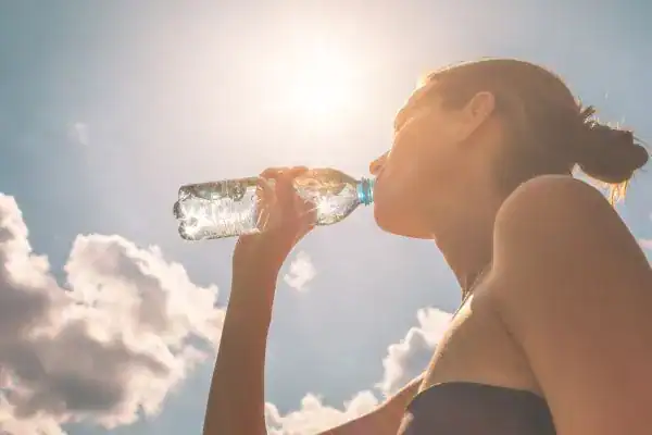 Hydration: The Secret Ingredient for a Toned Stomach and Enhanced Fitness 3 Image of woman drinking water to hydrate West Bridgford after run.